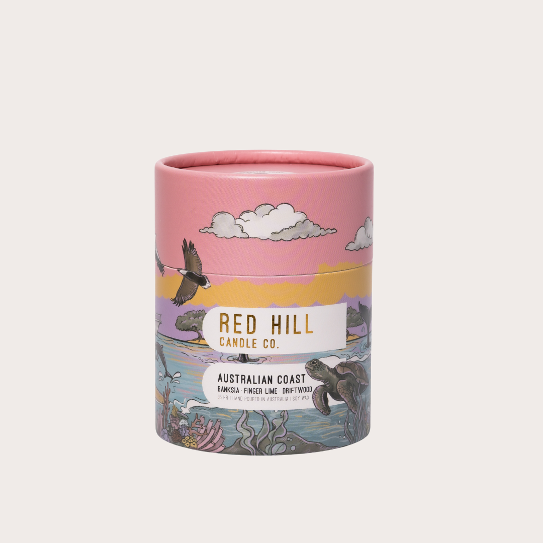 Candle packaging with 'Red Hill Candle Co.' branding and illustrations of nature on a white background