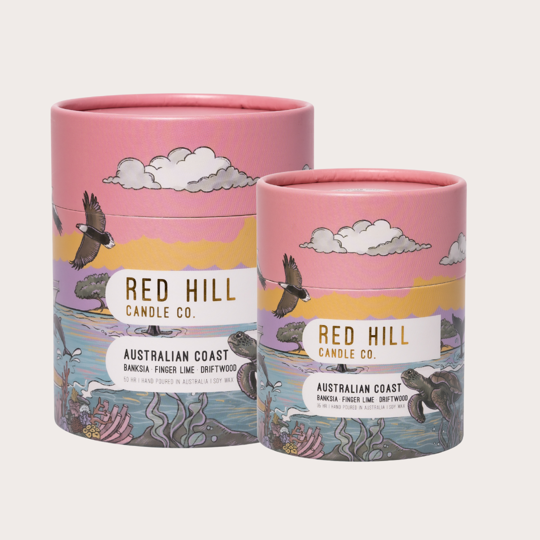 Two pink cylindrical candles with 'Red Hill Candle Co.' branding and Australian Coast design on a white background.